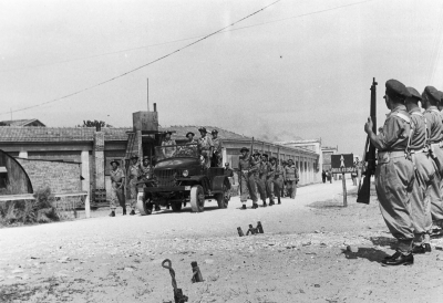 A funeral procession on the way to a cemetery. The casket with Adam Chruściel&#039;s body transported by a Studebaker US-6 truck. Soldiers armed with Lee-Enfield guns.